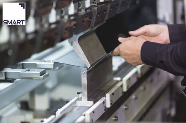 Thợ máy đang chế tác bộ phận kim loại trên máy chấn CNC